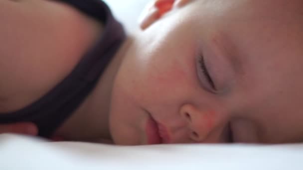 Маленький милый мальчик поворачивает голову во сне в замедленной съемке — стоковое видео