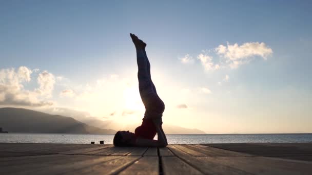 4k - kadın siluet yavaş hareket gün doğumunda deniz kenarında yoga yapıyor — Stok video