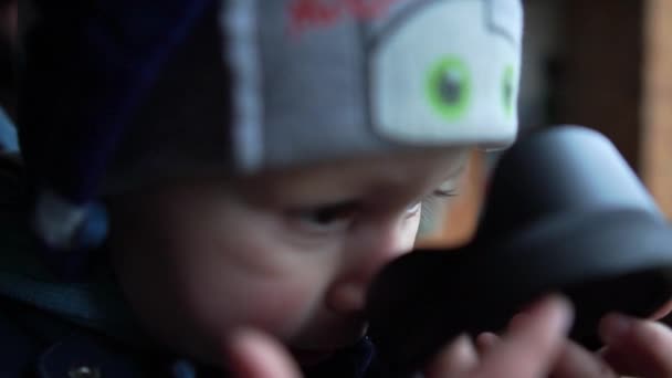 Grappige jongen met een vuile neus staande in een kleine winkel in de lente in slow motion — Stockvideo