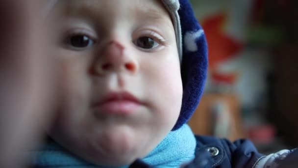 Cheery kid avec un nez sale debout dans un petit magasin au printemps au ralenti — Video