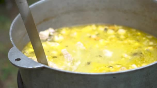 Caldron metallico con zuppa verde bollente e uno scoop che prende un po 'da esso in slo-mo — Video Stock