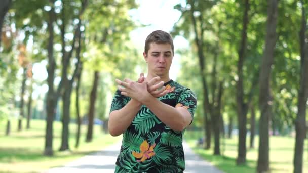 재미 있고 재미있는 남자는 공원에서 자신의 손으로 새를 보여줍니다. — 비디오