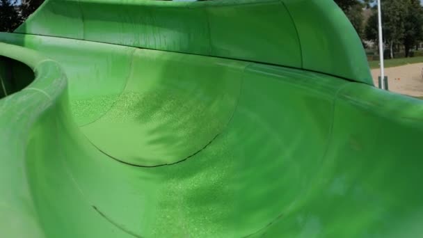 Joven rubia alegre desciende de un tobogán de agua en cámara lenta al aire libre — Vídeo de stock