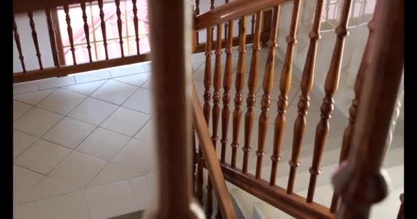 4K-σκάλα στο σπίτι, πηγαίνοντας κάτω με ένα ξύλινο κιγκλίδωμα σε αργή κίνηση — Αρχείο Βίντεο