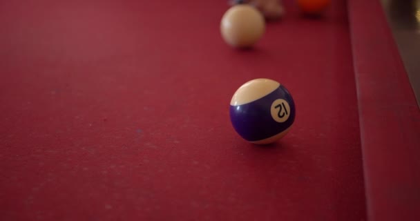 4k - Hitting the ball on a red pool table in slow motion — Stock Video