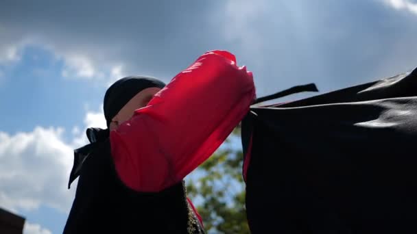 Ein Mann im ethnischen Kostüm wedelt mit rotem Tuch wie ein Torero in Zeitlupe — Stockvideo