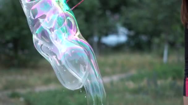 Mladá dívka používající speciální lana vytváří velké mýdlové bubliny na náměstí v pomalém pohybu — Stock video