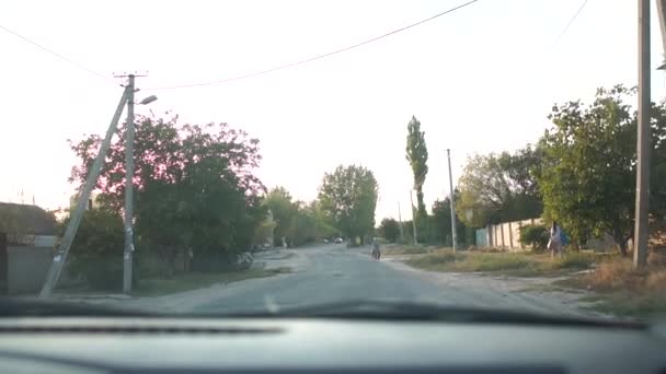 Estrada de campo passando por uma aldeia com pequenas casas e pessoas no verão — Vídeo de Stock