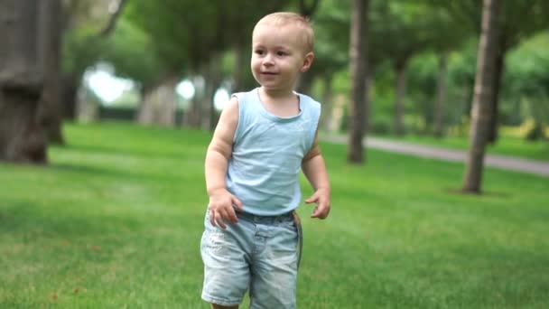 A cute toddler is walking in the park in slow motion — ストック動画