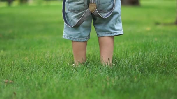 Little barefoot boys feet stomping on green grass close up in slow motion — Stock Video