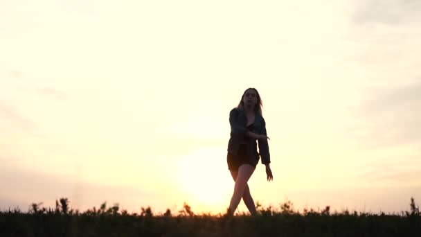 Молода танцівниця в джинсовій куртці і короткі шорти на заході сонця дія в повільному русі . — стокове відео