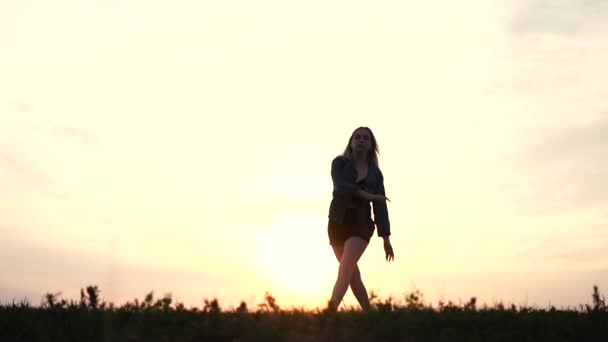 Joven bailarina con chaqueta de mezclilla y pantalones cortos de cordel al atardecer - la acción en cámara lenta. — Vídeos de Stock