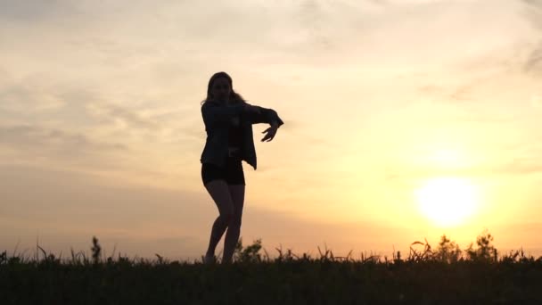 Salto bonito de uma menina com cabelo branco ao pôr do sol em câmera lenta, ela levanta a perna alta — Vídeo de Stock