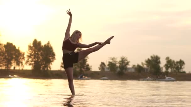 Young blonde dancer girl try make dance pose and have fail in the water. — Stock Video