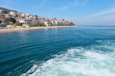İstanbul yakınlarındaki Mermer Denizi 'ndeki Prenslerin Adaları. Sahildeki küçük evler. Mavi suda beyaz köpük. Peyzaj İstanbul, Türkiye.