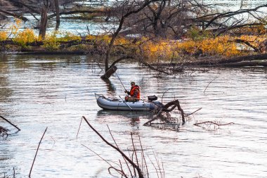 OB Nehri, Verkh-Suzun, Suzun ilçe, Novosibirsk bölgesi, Batı Sibirya, Rusya Federasyonu-22, Eylül 2018: Nehri üzerinde su dolu snags arasında bir şişme tekne balıkçılık balıkçı