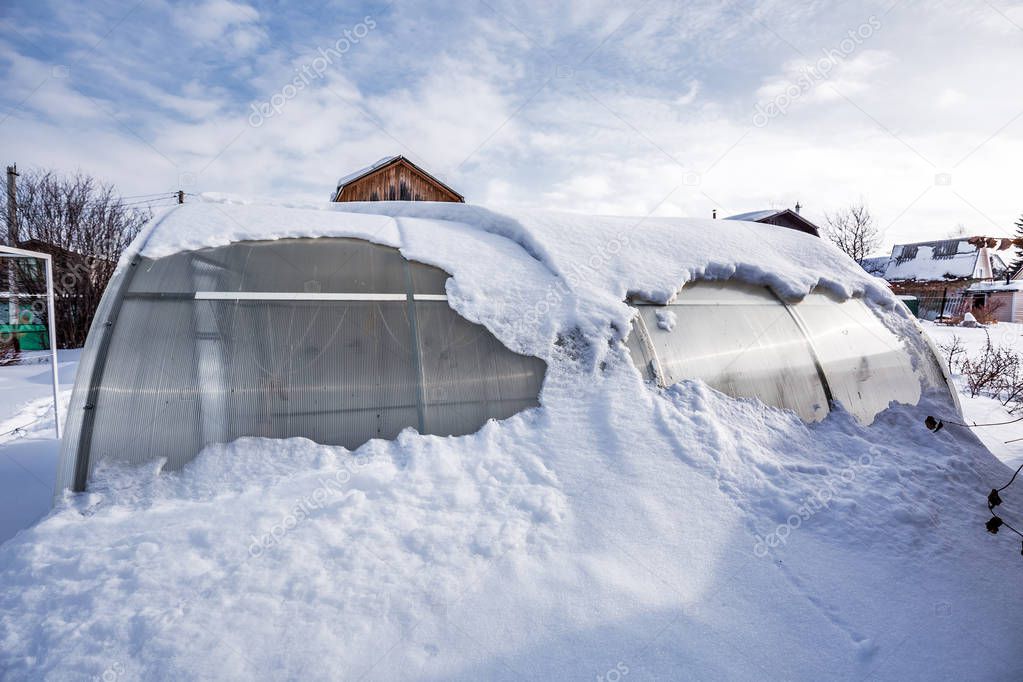 Snow-swept greenhouse made of polycarbonate in the country. Berdsk, Novosibirsk region, Western Siberia, Russia