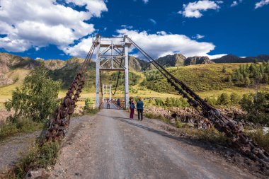 Chemalsky bölgesi, Altai Cumhuriyeti, Güney Sibirya, Rusya-19 Ağustos 2020: Oroktoysky otomobil asma köprüsü Katun nehri boyunca dağlarla çevrili beton sütunlar üzerinde