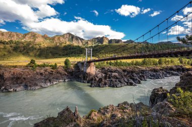 Chemalsky bölgesi, Altai Cumhuriyeti, Güney Sibirya, Rusya-19 Ağustos 2020: Oroktoysky otomobil asma köprüsü Katun nehri boyunca dağlarla çevrili beton sütunlar üzerinde