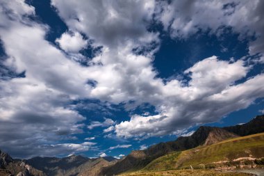 Altai dağlarının üzerindeki bulutlu gökyüzü. Altai Cumhuriyeti 'nin Oractical Köprüsü, Chemal Bölgesi