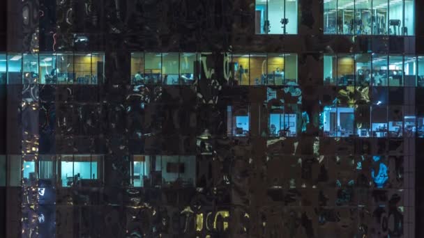 Ventanas del edificio de varios pisos de iluminación de vidrio y acero en el interior y personas en movimiento dentro de timelapse — Vídeos de Stock