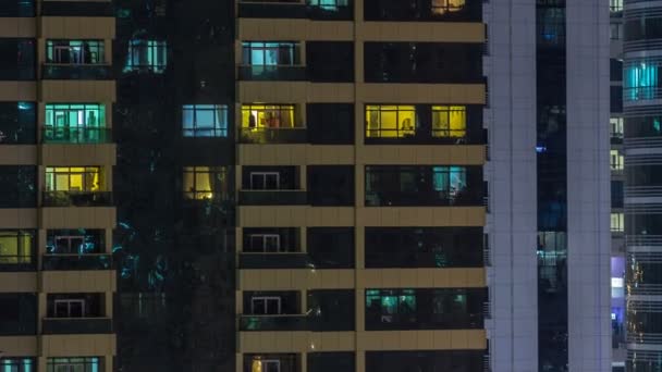 Fenster des mehrstöckigen Gebäudes aus Glas und Stahl Beleuchtung im Inneren und bewegen Menschen im Zeitraffer — Stockvideo