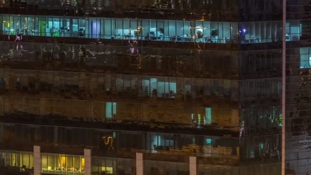 Ventanas del edificio de varios pisos de iluminación de vidrio y acero en el interior y personas en movimiento dentro de timelapse — Vídeo de stock