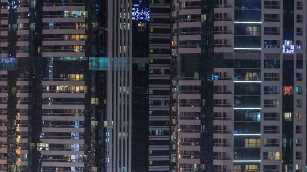 窗户的多层建筑玻璃和钢照明内和移动的人在 Timelapse 迪拜现代住宅摩天大楼的鸟瞰图 平底锅 — 图库视频影像