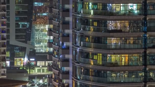 Windows av flera våningar byggnad av glas och stål belysning inuti och flytta människor inom timelapse — Stockvideo