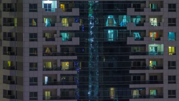 Ventanas del edificio de varios pisos de iluminación de vidrio y acero en el interior y personas en movimiento dentro de timelapse — Vídeos de Stock