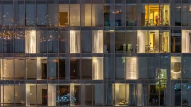 Windows çok katlı binanın içinde aydınlatma ve insanlar timelapse içinde hareketli çelik ve cam
