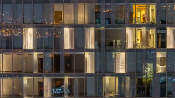 Ventanas del edificio de varios pisos de iluminación de vidrio y acero en el interior y personas en movimiento dentro de timelapse — Vídeo de stock