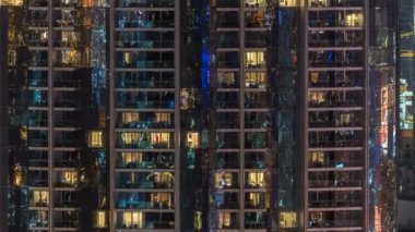 Windows çok katlı binanın içinde aydınlatma ve insanlar timelapse içinde hareketli çelik ve cam. Dubai merkezinde modern konut gökdelenlerin havadan görünümü. Vınlamak dışarı