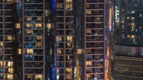 Fenster des mehrstöckigen Gebäudes aus Glas und Stahl Beleuchtung im Inneren und bewegen Menschen im Zeitraffer — Stockvideo