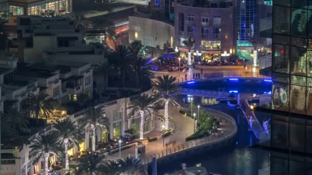 Променад и канал в Dubai Marina с роскошными небоскребами и яхтами вокруг ночного времени, Объединенные Арабские Эмираты — стоковое видео