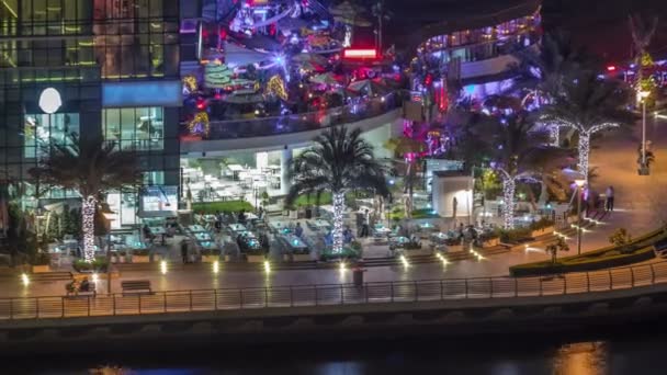 Promenade en kanaal in Dubai Marina met luxe wolkenkrabbers en jachten rond nacht timelapse, Verenigde Arabische Emiraten — Stockvideo