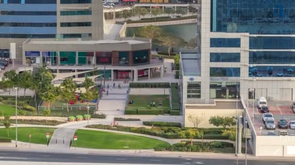 Vista aérea da área verde perto de Jumeirah lagos torres arranha-céus timelapse com estacionamento — Vídeo de Stock