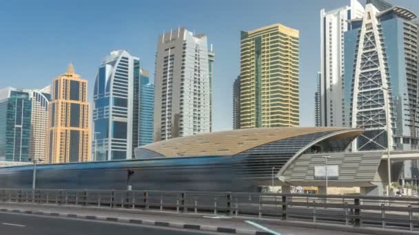 Utsikt över Jumeirah lakes towers skyskrapor och metro sration timelapse med trafik på sheikh zayed road. — Stockvideo