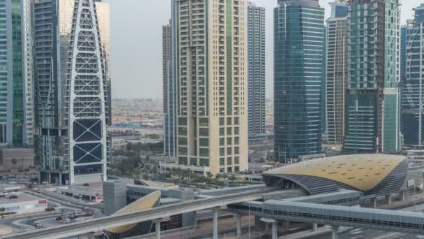 Vista aérea de las torres de los lagos de Jumeirah rascacielos día a noche timelapse con el tráfico en la carretera sheikh zayed . — Vídeos de Stock