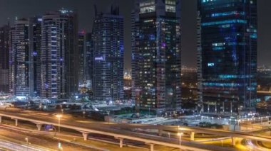 Jumeirah lakes towers gökdelenler gece timelapse trafik ile havadan görünümü Şeyh zayed yolu üzerinde.