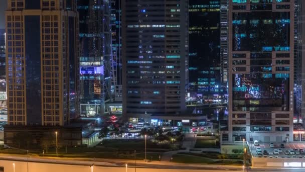 Letecký pohled na Jumeirah lakes věže mrakodrapů noční timelapse s provozem na bulváru sheikh zayed road. — Stock video