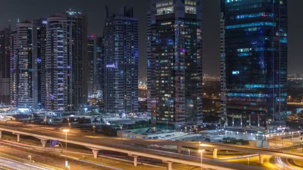 A légi felvétel a Jumeirah lakes towers felhőkarcolók éjjel timelapse forgalom, a sheikh zayed úton. — Stock videók