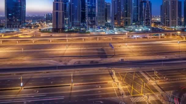 Flygfoto över Jumeirah lakes towers skyskrapor natt till dag timelapse med trafik på sheikh zayed road. — Stockvideo