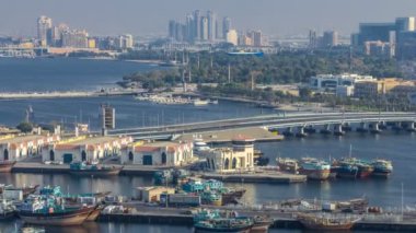 Dubai creek manzara timelapse tekneler ve gemi limanda ve gün batımı sırasında arka planda modern binalar