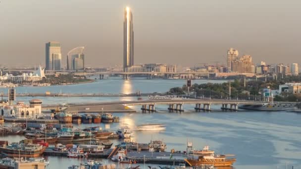 Dubai creek landschap timelapse met boten en schip in de haven en moderne gebouwen in de achtergrond tijdens zonsondergang — Stockvideo