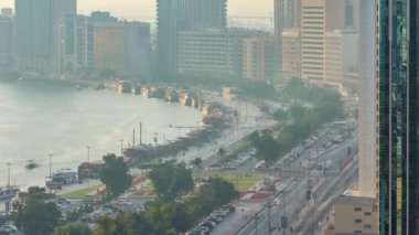 Dubai creek manzara timelapse tekneler ve gemi limanda ve gün batımı sırasında arka planda modern binalar