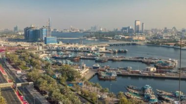 Dubai creek manzara timelapse tekneler ve gemi limanda ve gün batımı sırasında arka planda modern binalar