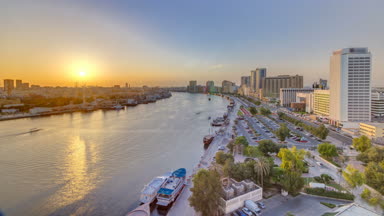 Dubai creek manzaraya tekneler ve waterfront yakınındaki gemi günbatımı timelapse