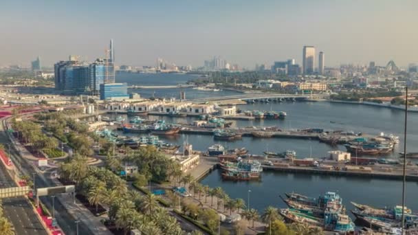 Dubai Creek Landschaft Zeitraffer mit Booten und Schiffen im Hafen und modernen Gebäuden im Hintergrund bei Sonnenuntergang — Stockvideo