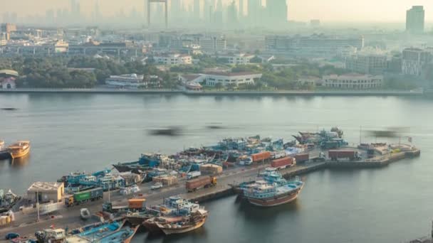 Dubai creek paisagem timelapse com barcos e navios no porto e edifícios modernos no fundo durante o pôr do sol — Vídeo de Stock